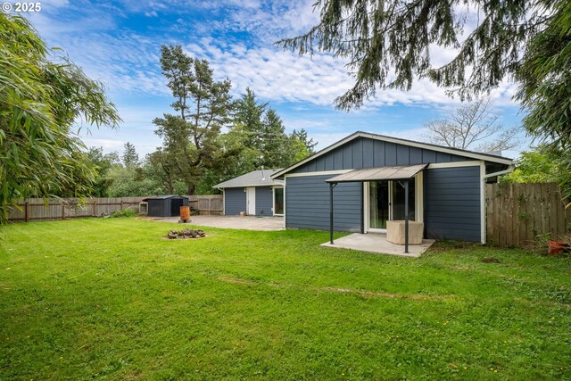 567 NW Cedar Ct, Warrenton, OR 97146 - back of property featuring a patio, a fenced backyard, board and batten siding, and a shed