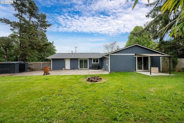 567 NW Cedar Ct, Warrenton, OR 97146 - back of property featuring a patio area, a fenced backyard, and a storage unit