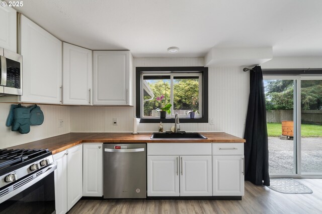 567 NW Cedar Ct, Warrenton, OR 97146 - kitchen with appliances with stainless steel finishes, wood counters, plenty of natural light, and light wood-style flooring