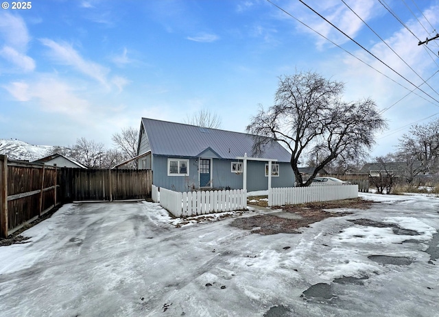 view of front of house featuring a fenced front yard and metal roof