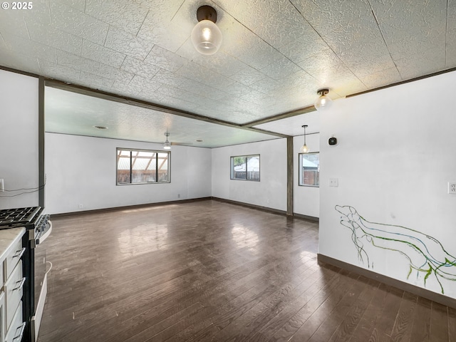 spare room with a ceiling fan, dark wood-style flooring, and baseboards