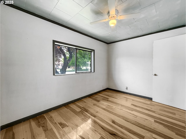 spare room featuring light wood-type flooring, crown molding, baseboards, and ceiling fan