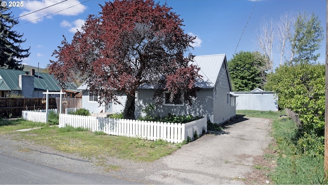 view of front of property featuring metal roof and a fenced front yard