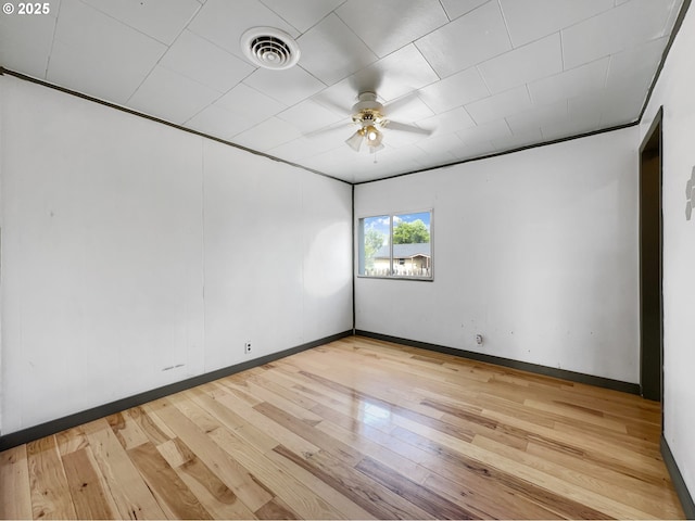 empty room featuring ceiling fan, light wood-style flooring, visible vents, and baseboards