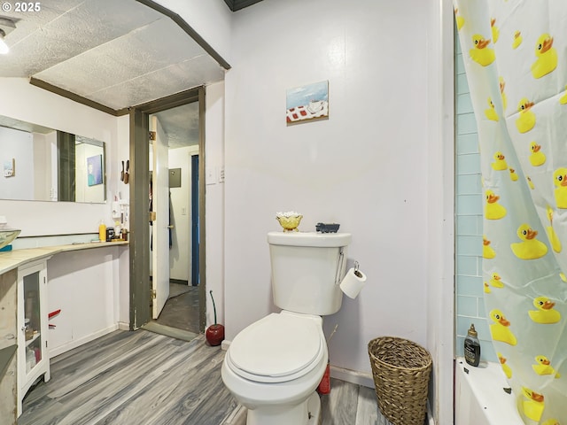 bathroom featuring shower / bath combination with curtain, toilet, and wood finished floors