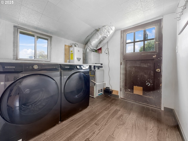 laundry area featuring a wealth of natural light, laundry area, water heater, and wood finished floors