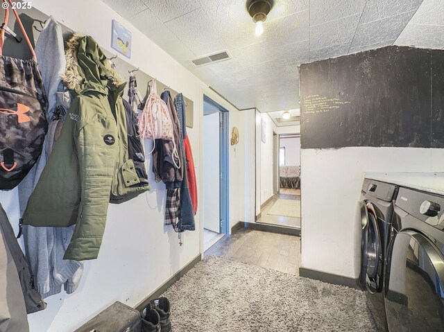 clothes washing area featuring laundry area, visible vents, baseboards, light wood-style floors, and independent washer and dryer