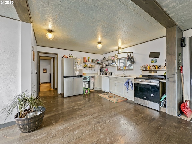 kitchen featuring dark wood-style flooring, a sink, white cabinets, appliances with stainless steel finishes, and open shelves