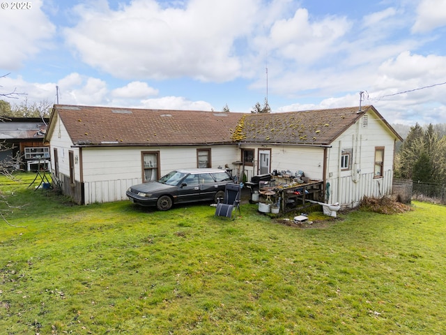 back of house featuring fence and a yard