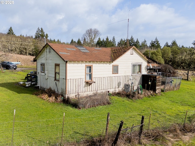 rear view of property featuring a yard, cooling unit, and fence