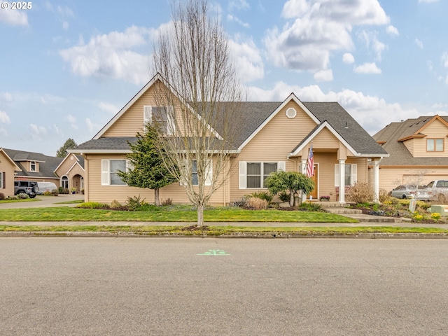 view of front of property with a front lawn and roof with shingles