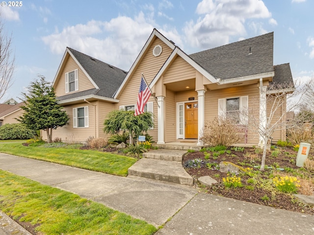 view of front of home featuring a front yard and a shingled roof