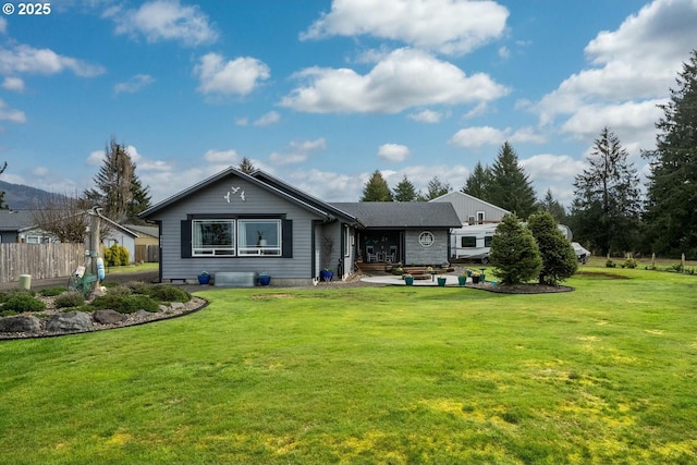 rear view of house with a yard and fence