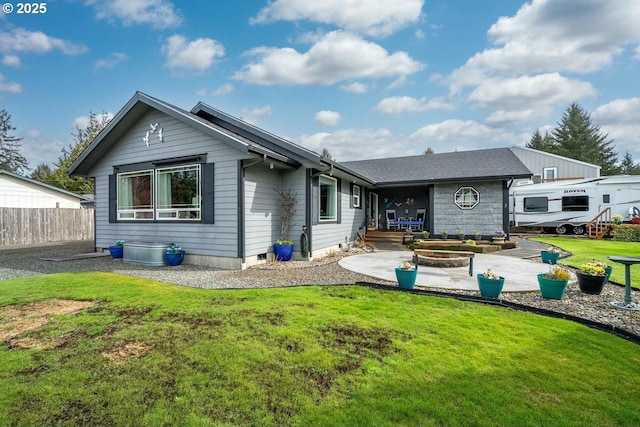 back of house featuring fence, a lawn, and a patio area