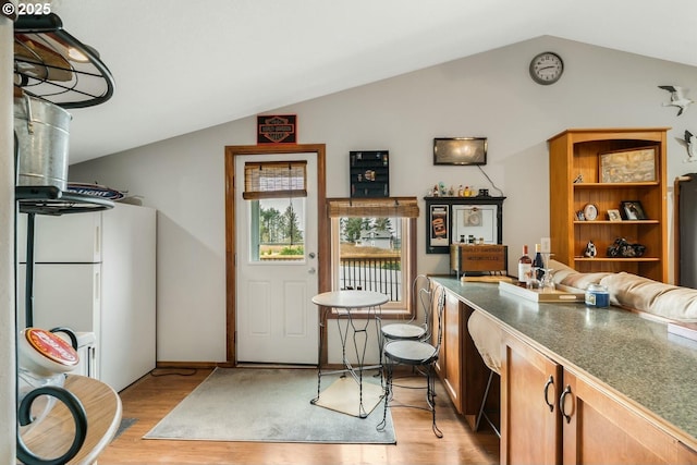 7655 Elliott St, Bay City, OR 97107 - bar featuring light wood-style floors, baseboards, freestanding refrigerator, and lofted ceiling