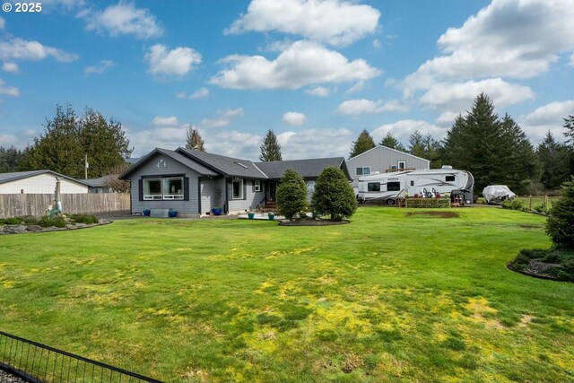 back of property featuring a lawn and fence