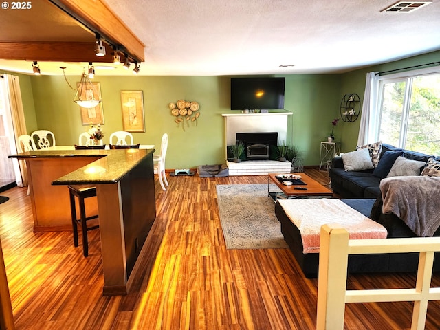 living room with rail lighting, hardwood / wood-style floors, and a textured ceiling