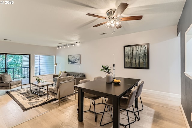7573 N Edgewater Ave, Portland, OR 97203 - dining room with light wood finished floors, ceiling fan, and baseboards