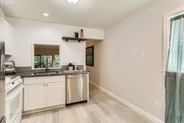 7573 N Edgewater Ave, Portland, OR 97203 - kitchen with dishwasher, a sink, white electric stove, light wood-style flooring, and white cabinetry