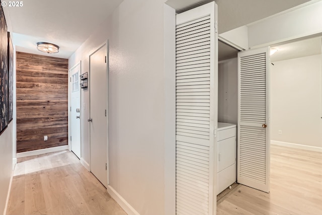 7573 N Edgewater Ave, Portland, OR 97203 - hallway featuring wood walls, light wood-style flooring, washer / clothes dryer, and baseboards