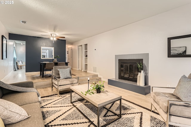 7573 N Edgewater Ave, Portland, OR 97203 - living area featuring light wood-type flooring, a glass covered fireplace, ceiling fan, and baseboards