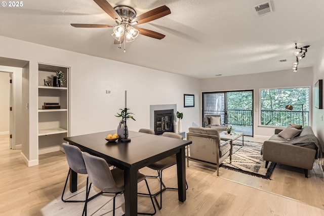 7573 N Edgewater Ave, Portland, OR 97203 - dining space featuring light wood-style flooring, baseboards, ceiling fan, built in features, and a textured ceiling