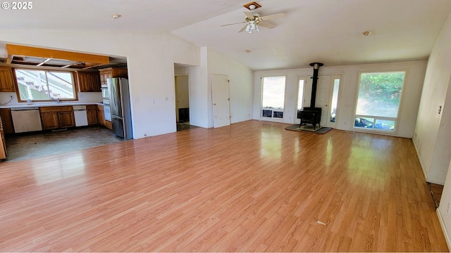 48495 Mcfarland Rd, Oakridge, OR 97463 - unfurnished living room with a wood stove, lofted ceiling, healthy amount of natural light, light wood-style floors, and ceiling fan
