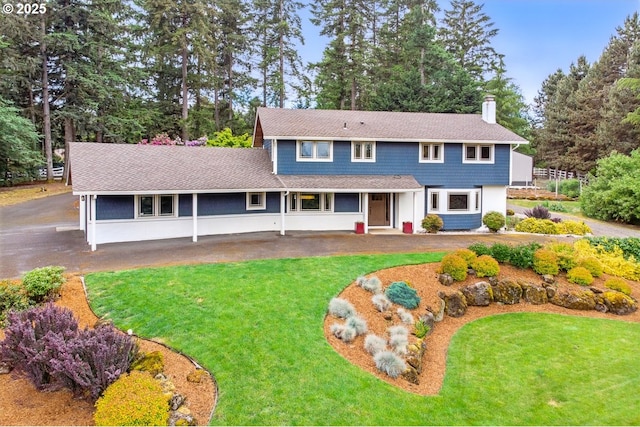24601 SW 65th Ave, Tualatin, OR 97062 - traditional-style home with a front lawn, a porch, view of wooded area, and a chimney