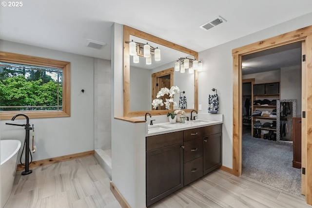 24601 SW 65th Ave, Tualatin, OR 97062 - bathroom featuring double vanity, a soaking tub, baseboards, tiled shower, and a spacious closet