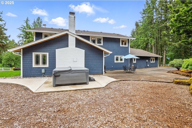 24601 SW 65th Ave, Tualatin, OR 97062 - rear view of house with a hot tub, a patio area, and a chimney