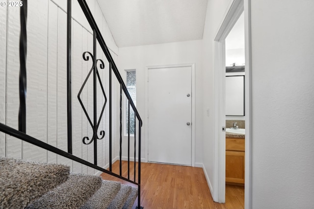 stairs with sink and wood-type flooring