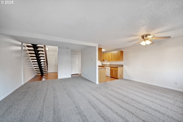 unfurnished living room with ceiling fan, light colored carpet, and a textured ceiling