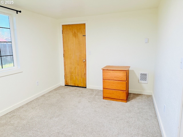 unfurnished room with visible vents, baseboards, and light carpet