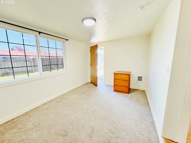 unfurnished bedroom featuring visible vents, carpet flooring, and baseboards
