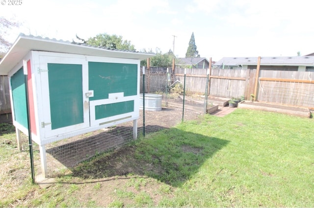view of yard with exterior structure, a garden, an outbuilding, and a fenced backyard