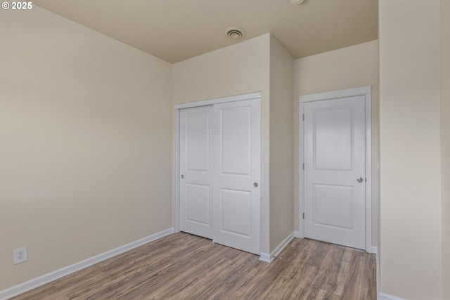 unfurnished bedroom with hardwood / wood-style floors and a closet