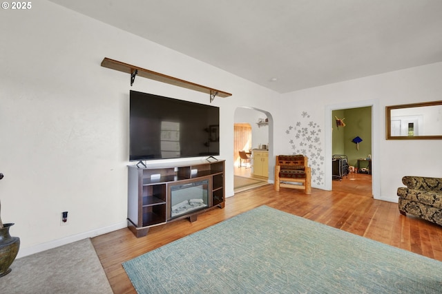 803 Main St, Philomath, OR 97370 - living area featuring wood finished floors, arched walkways, baseboards, and a fireplace