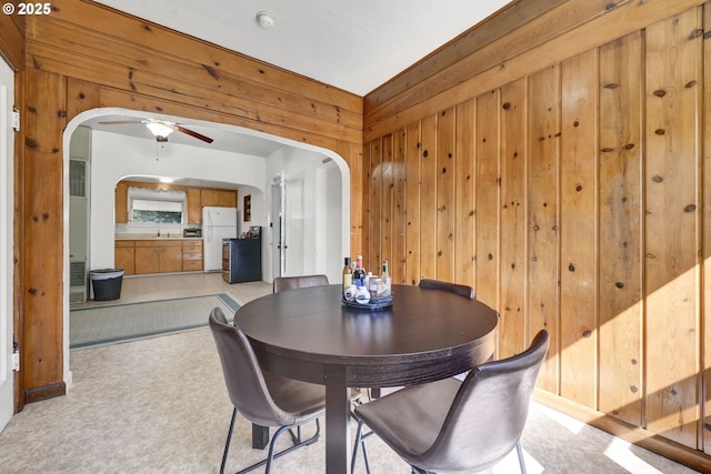 803 Main St, Philomath, OR 97370 - dining area with arched walkways, wood walls, light colored carpet, and ceiling fan