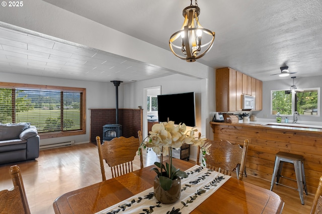 1175 Northside Rd, Sutherlin, OR 97479 - dining area featuring a wood stove, healthy amount of natural light, and light wood-type flooring
