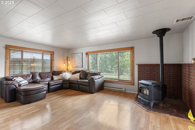 1175 Northside Rd, Sutherlin, OR 97479 - living room featuring a wood stove, plenty of natural light, wood finished floors, and a baseboard heating unit