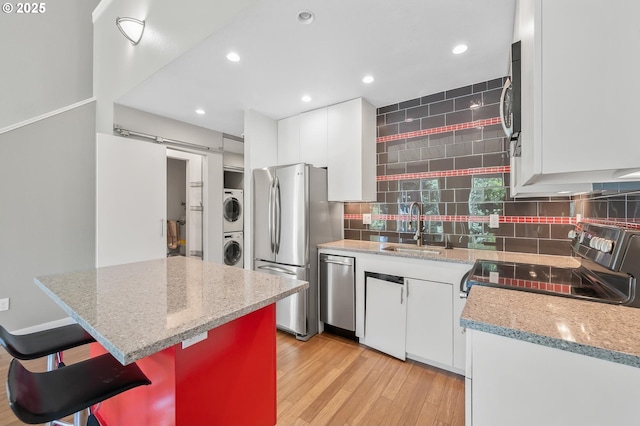 4 Touchstone # 138, Lake Oswego, OR 97035 - kitchen featuring estacked washer and dryer, a sink, stainless steel appliances, decorative backsplash, and recessed lighting