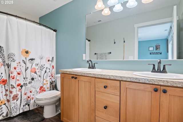 bathroom featuring vanity, toilet, and wood-type flooring