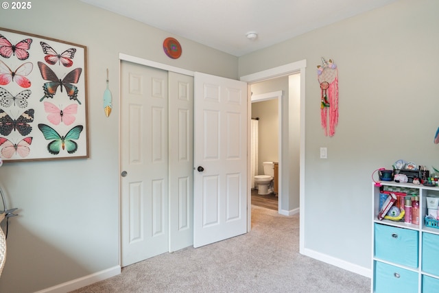 bedroom featuring light carpet and a closet