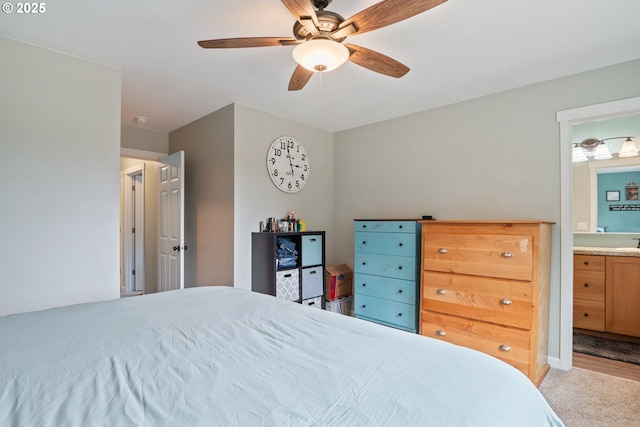 bedroom featuring sink, ensuite bath, light colored carpet, and ceiling fan