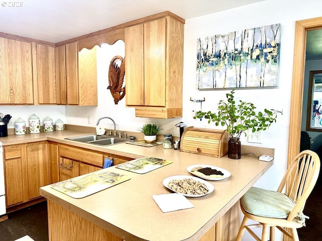 1021 Starlight St, The Dalles, OR 97058 - kitchen featuring a sink, light countertops, a peninsula, a breakfast bar area, and light brown cabinetry