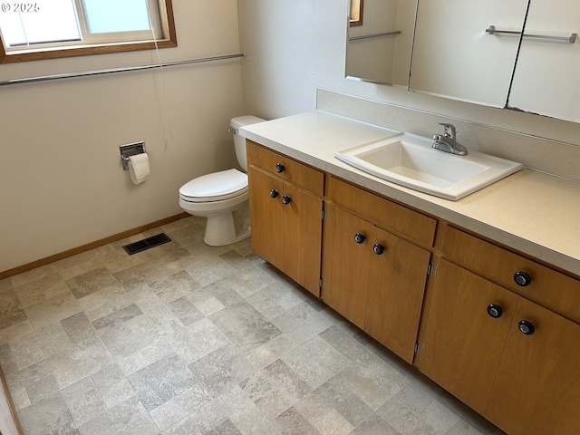 bathroom featuring vanity, toilet, baseboards, and visible vents