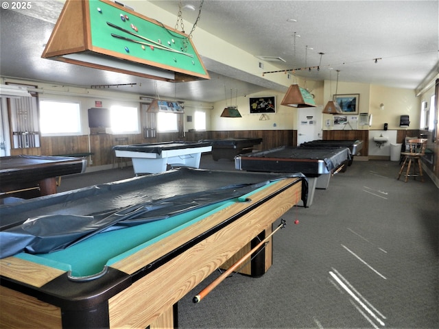 rec room with billiards, wooden walls, wainscoting, and a textured ceiling