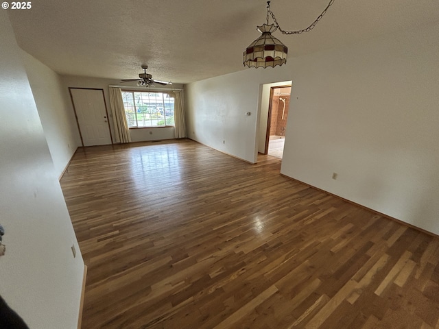 interior space featuring a textured ceiling, ceiling fan, and wood finished floors