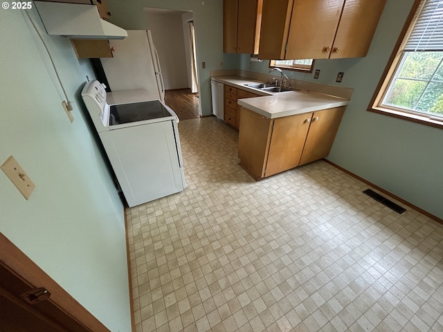 kitchen featuring white appliances, visible vents, washer / clothes dryer, a sink, and light countertops