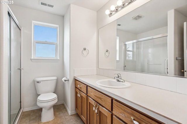 bathroom featuring vanity, toilet, a shower with shower door, and tile patterned flooring